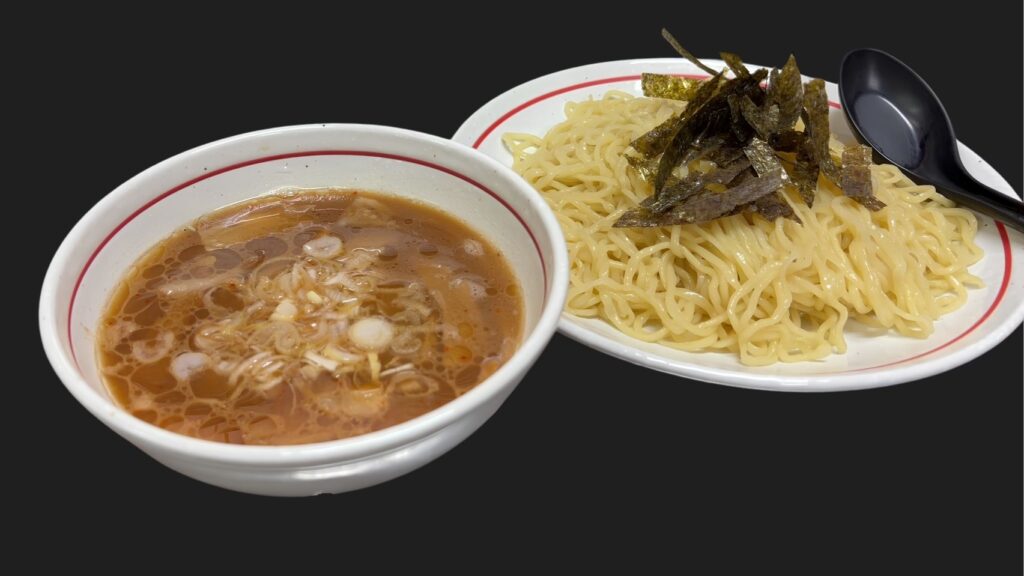 富士市で本格的なつけ麺・ラーメンを提供する「つけ麺処Sin 富士本店」の看板メニュー。ネギが浮かぶ濃厚な特製スープと、海苔が添えられた艶やかな麺の盛り合わせ。